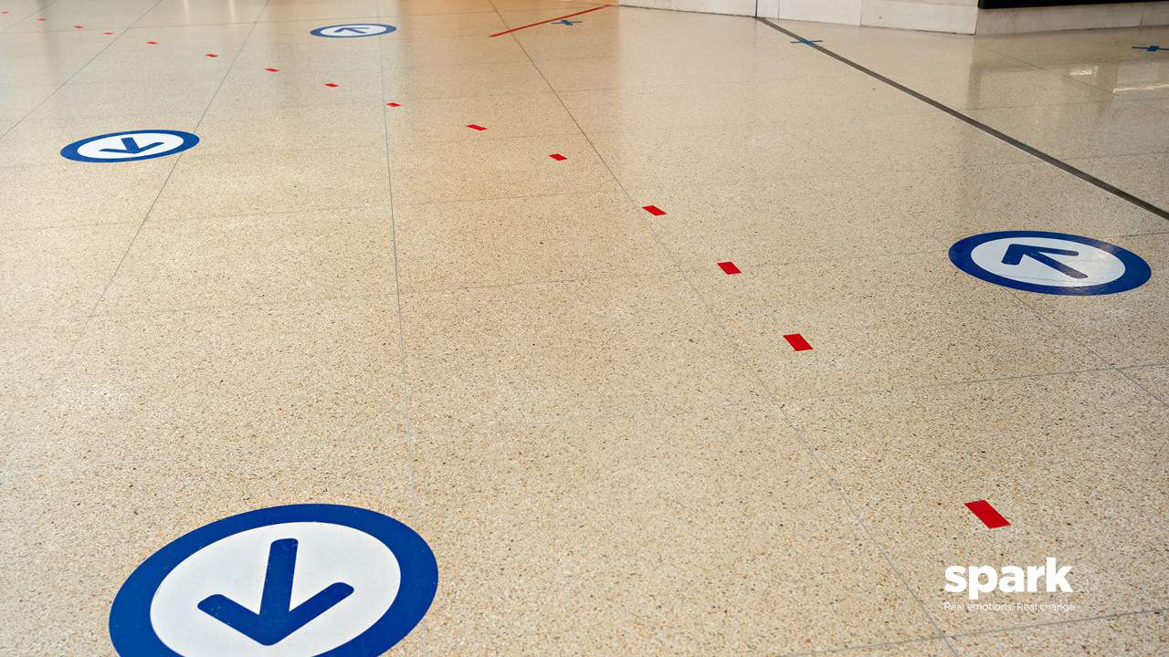 Floor sticker social distancing arrows in UK supermarket Tesco COVID