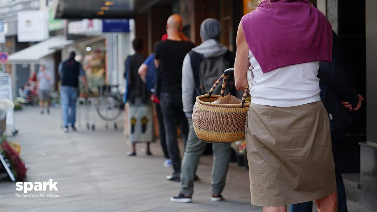 Shoppers queing outside supermarket COVID