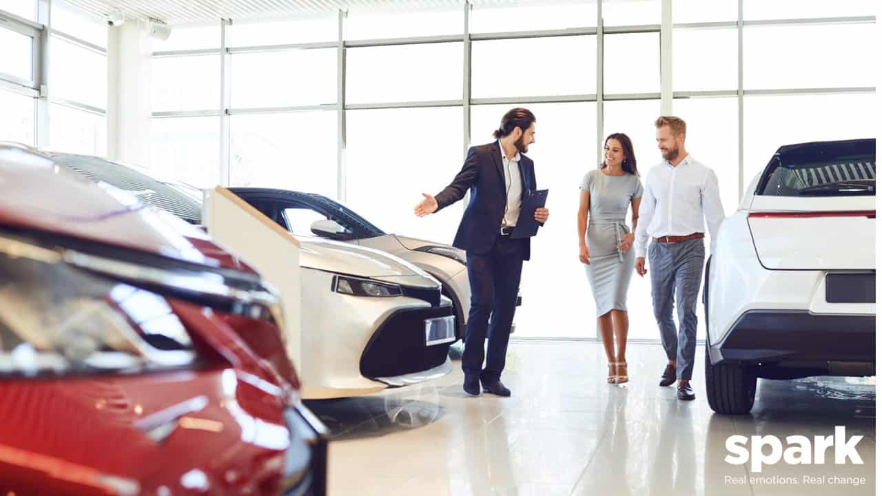 Man and woman shopping for a new car in a showroom