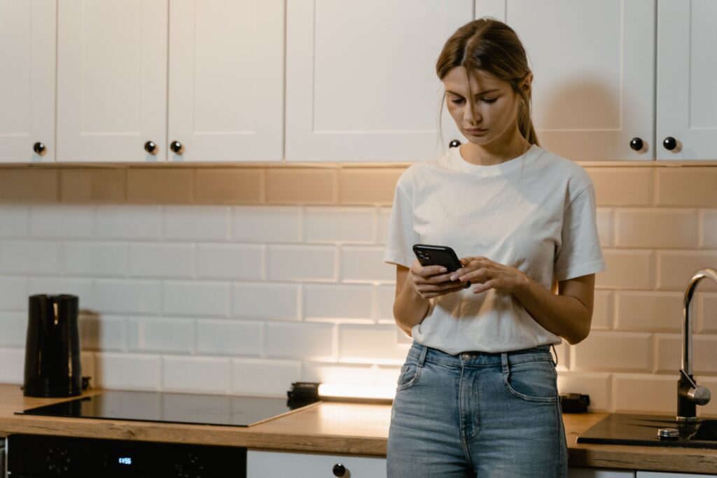 A consumer using a smartphone at home for mobile ethnography, demonstrating real-world context in FMCG market research.