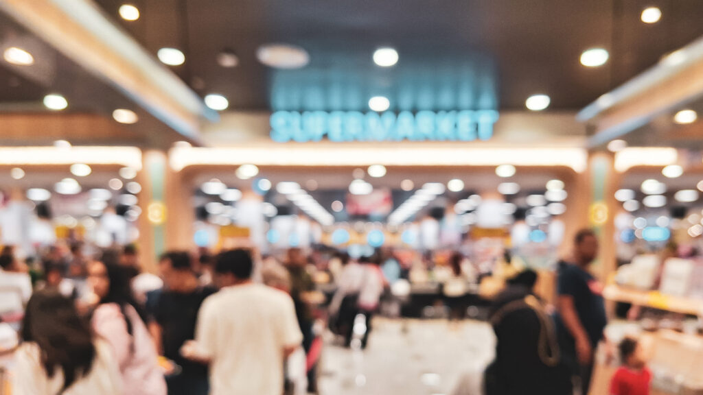 A blurred and crowded supermarket aisle, illustrating the visual noise and cognitive friction that occurs when processing fluency is ignored.