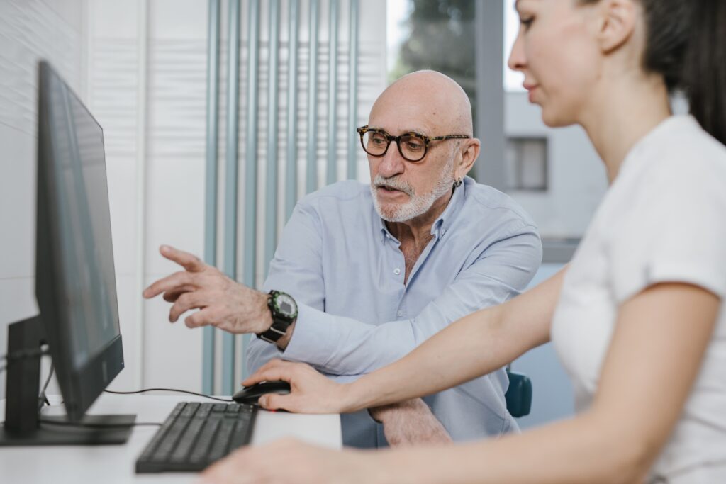 Two data specialists carefully reviewing survey responses on a monitor, demonstrating the human expertise required to ensure high data quality in consumer research.
