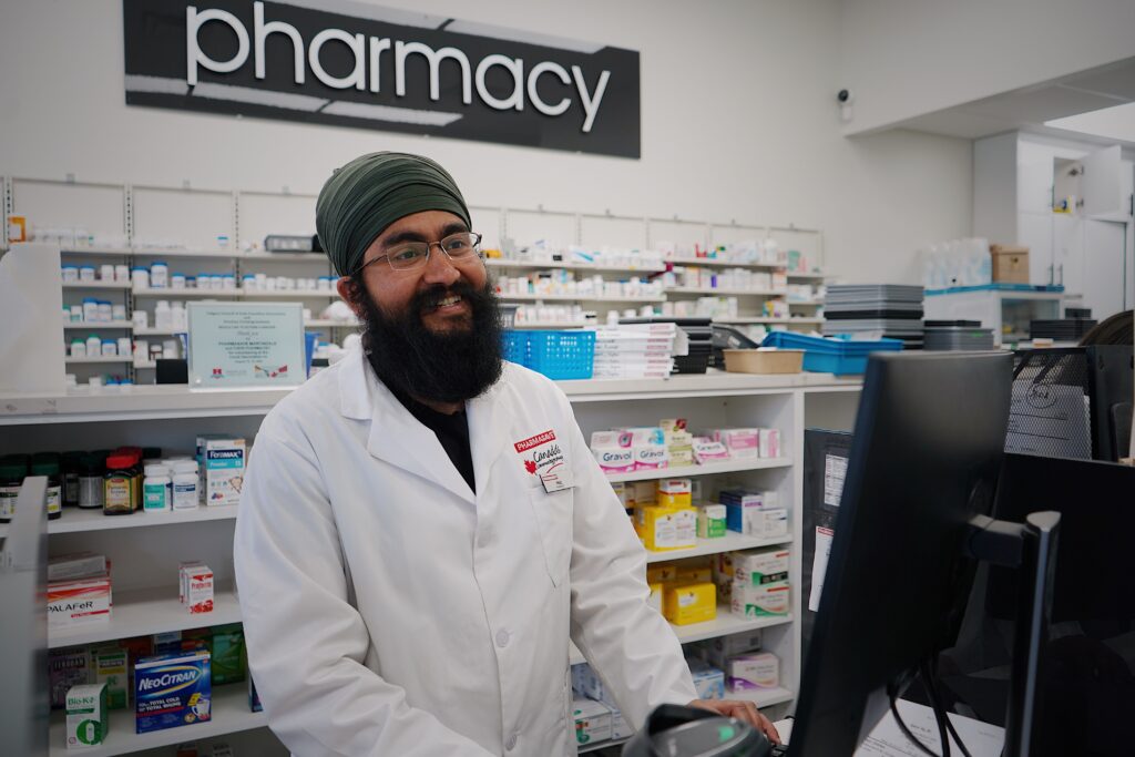 A reassuring pharmacist in a retail pharmacy, illustrating how the right environment and messaging can shift customer emotions from fear to confidence.